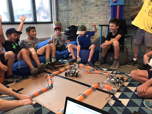 group of youth watching robots