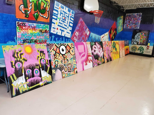 colourful paintings lined up against a wall