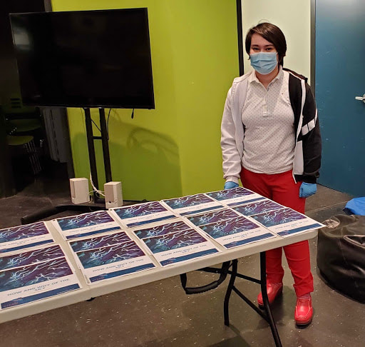 person standing at table covered in posters